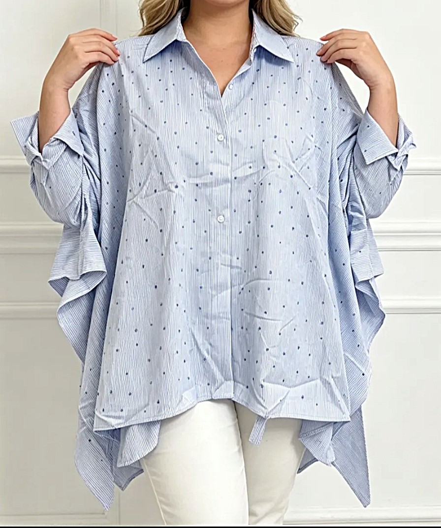 Femme portant une blouse ample bleu ciel à pois, grande taille, avec pantalon blanc